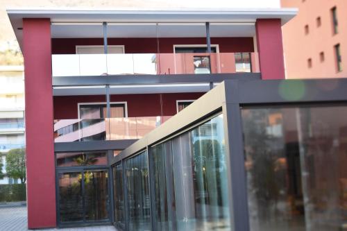 a red building with glass windows in front of it at Hotel Bellavista Locarno in Locarno