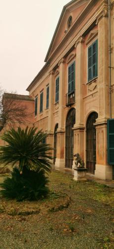a large building with a palm tree in front of it at Il Castello di Bubbio in Bubbio