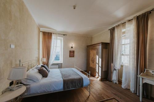 a bedroom with a bed and a large window at Il Castello di Bubbio in Bubbio