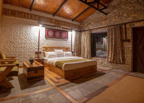 a bedroom with a bed and a brick wall at BluSalzz Homes - The Himalayan Bungalow, Almora - Uttarakhand in Almora