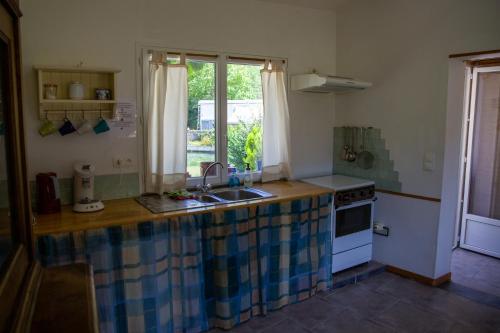 une cuisine avec un évier, une cuisinière et une fenêtre dans l'établissement Studio à Deux au Blagour, à Lachapelle-Auzac
