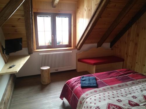 a bedroom with a bed with a red blanket and a window at Greuth Hutte in Tarvisio