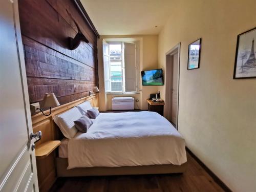 a bedroom with a large bed with a wooden headboard at Chalet Lucca in Lucca