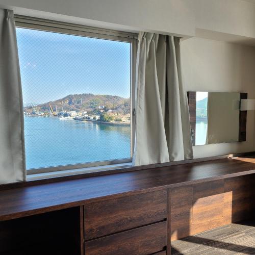 a large window with a view of the water at Sakura Shimanami Hotel in Onomichi