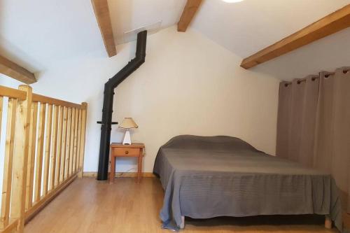 1 dormitorio con 1 cama y suelo de madera en Gite Le Maty en Saint-André-Capcèze