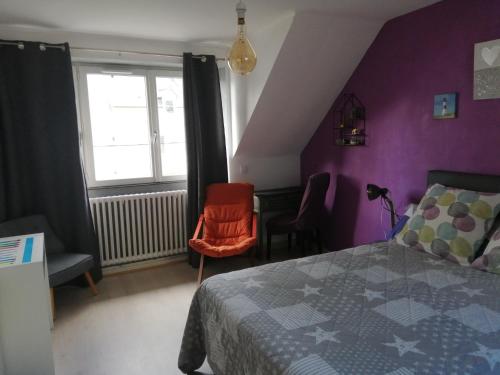 - une chambre avec des murs violets, un lit et une fenêtre dans l'établissement GINGER, à Cancale