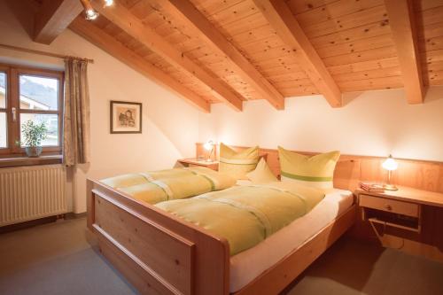 ルーポルディングにあるHaus Gstatterのベッドルーム1室(大型ベッド1台、黄色い枕付)