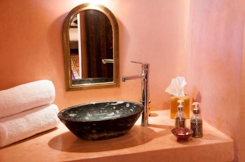 La salle de bains est pourvue d'un lavabo et d'un miroir. dans l'établissement Dar Sofar, à Agdz