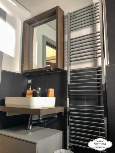a bathroom with a sink and a mirror at Vittoria Casa Vacanza in Madesimo