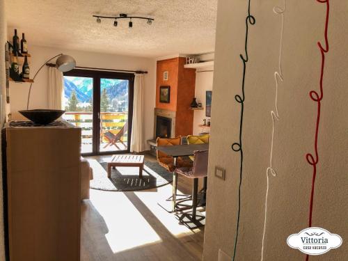 eine Küche und ein Wohnzimmer mit Blick auf ein Wohnzimmer in der Unterkunft Vittoria Casa Vacanza in Madesimo