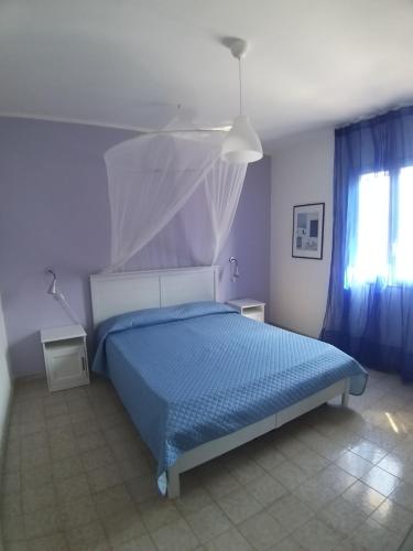 プンタ・セッカにあるCasa Danielaのベッドルーム1室(青い掛け布団、窓付)