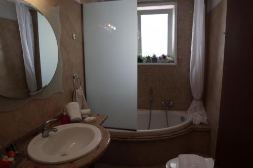 a bathroom with a sink and a tub and a mirror at Seascape Village in Kalithies