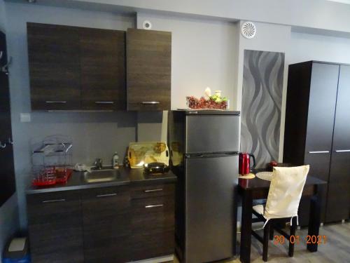 a kitchen with a stainless steel refrigerator and a table at Noclegi nad Morzem u Kasi in Gdańsk