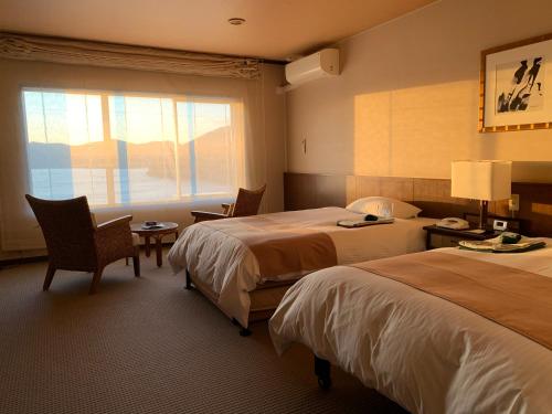 a hotel room with two beds and a window at Premier Resort Yuga Ise Shima in Shima