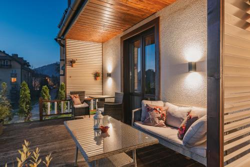 a patio with a couch and a table on a balcony at Pieninski Mak. in Szczawnica