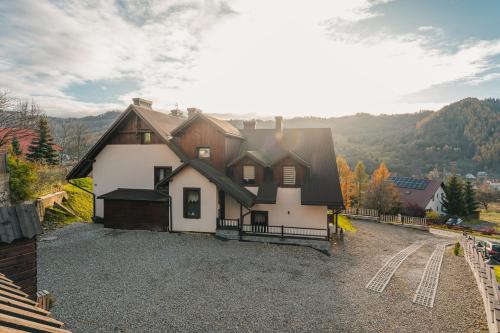 a large white house with a black roof at Pieninski Mak. in Szczawnica