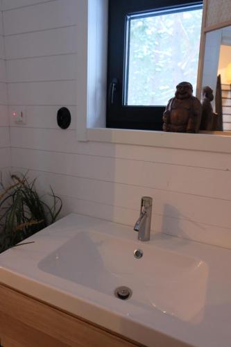 lavabo blanco en el baño con espejo en Kalana Virve Holiday Villa, en Kalana