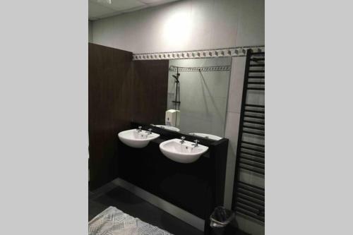 a bathroom with two sinks and a mirror at The Loft @ Clifden Bay Apartments in Clifden