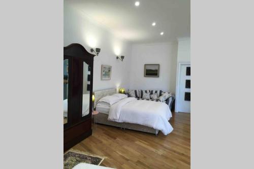 sypialnia z dużym łóżkiem i dużym lustrem w obiekcie The Loft @ Clifden Bay Apartments w mieście Clifden
