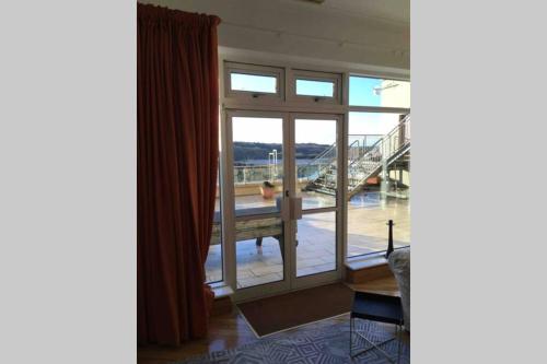 a room with a large glass door and a balcony at The Loft @ Clifden Bay Apartments in Clifden