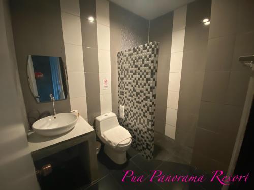 a bathroom with a sink and a toilet and a mirror at Pua Panorama Resort in Nan