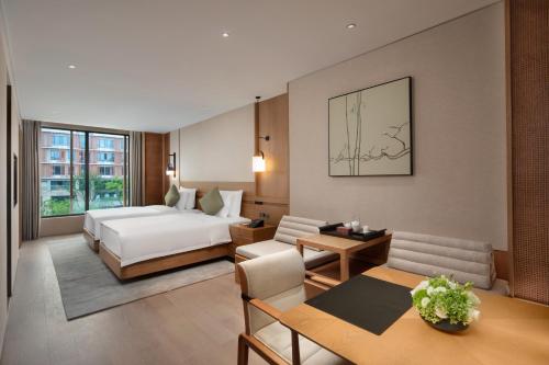 南京市にあるGrand WUJI Hotel, in The Unbound Collection by Hyattのベッドとリビングルームがあるホテルの部屋