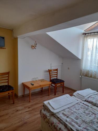 a bedroom with two beds and a table and chairs at Yana Guest House in Dobrinishte