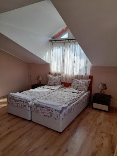 Un dormitorio con una cama grande y una ventana en Yana Guest House en Dobrinishte