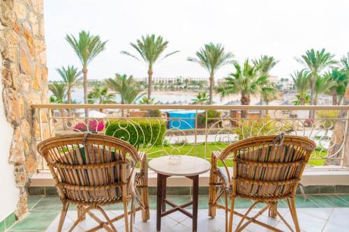 a balcony with two chairs and a table with a view at Brayka Bay Reef Resort in Abu Dabab