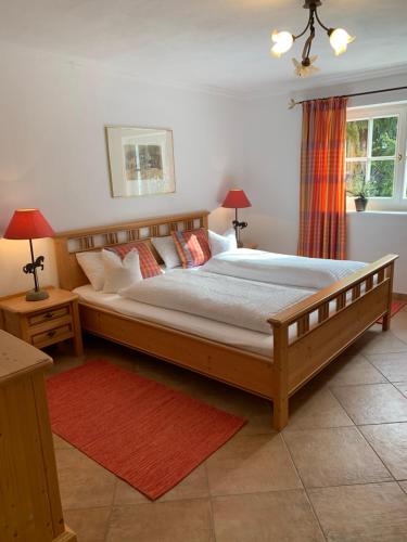 Un dormitorio con una gran cama de madera con almohadas en Wagner Häusl, en Saalbach Hinterglemm