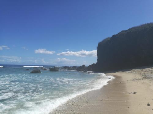 une plage de sable avec des rochers dans l'océan dans l'établissement Appart Alexina, 2mn à pieds de la plage de BOUCAN-CANOT, à Saint-Gilles les Bains