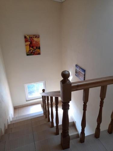 a staircase with a wooden rail and a window at Yana Guest House in Dobrinishte