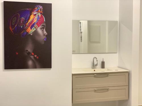 a bathroom with a painting of a woman with a hat at Uyut apartments in Majdal Shams