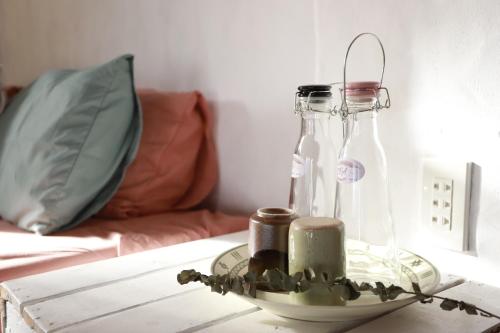 a table with two glass bottles on a table at EVA HUT Mui Ne Beach Hostel in Mui Ne