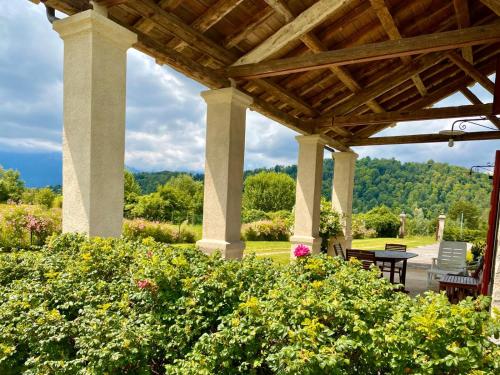 an outdoor pavilion with a table and chairs and flowers at Fienile Chiaramada in Belluno