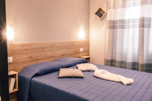 1 dormitorio con 1 cama azul y 2 almohadas en Affittacamere Orchidea, en Módena