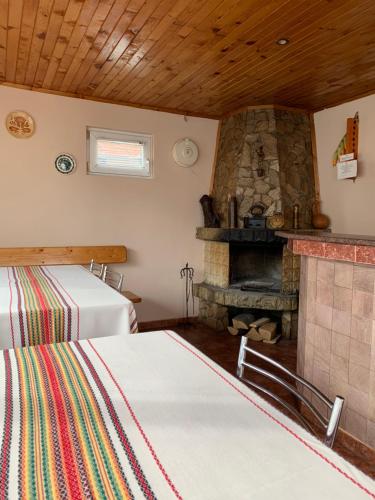 a room with two beds and a stone fireplace at Sunny House Madjare Guest House in Madzhare