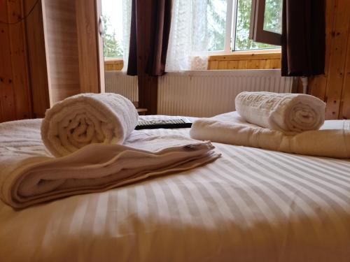 a bed with towels on it with a window at Cabana Mălina Vârtop in Vîrtop