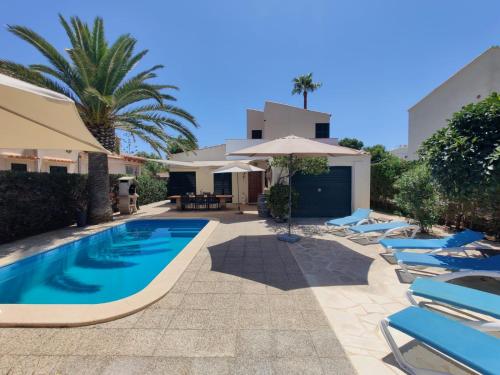 una piscina con tumbonas y sombrilla en Finca Ses Rotes en Cala Llombards