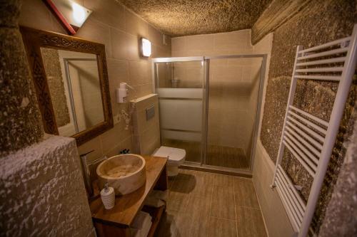 a bathroom with a sink and a shower and a toilet at Stone House Cave Hotel in Goreme