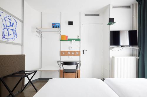 - une petite chambre avec 2 lits et un bureau dans l'établissement French Theory, à Paris