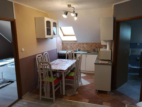 una cucina con un tavolo e sedie in una stanza di Beni Haus a Balatongyörök