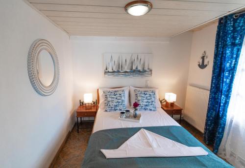 Schlafzimmer mit einem Bett mit blauen und weißen Kissen in der Unterkunft Captain's Villa in Skiathos-Stadt