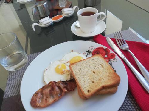 a plate with eggs sausage and toast and a cup of coffee at Diamond Plaza in Grand Anse