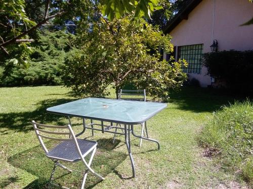 a ping pong table and two chairs in a yard at Cabañas Las Lavandas en Pilar in Pilar