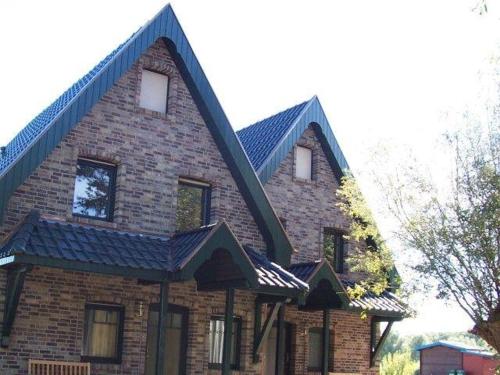 ein großes Backsteinhaus mit Spitzdach in der Unterkunft Zur alten Schmiede II Haus II in Boltenhagen