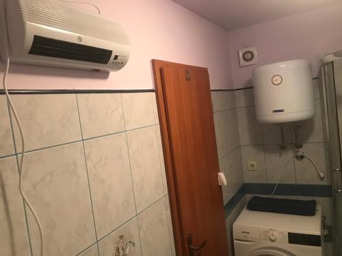 a small bathroom with a toilet and a microwave at Apartment in family house Linda in Čavle