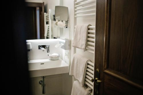 a bathroom with a sink and a mirror and towels at Friesachers Aniferhof in Anif
