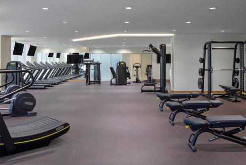 a gym with rows of treadmills and machines at Avani Plus Palm View Dubai Hotel & Suites in Dubai