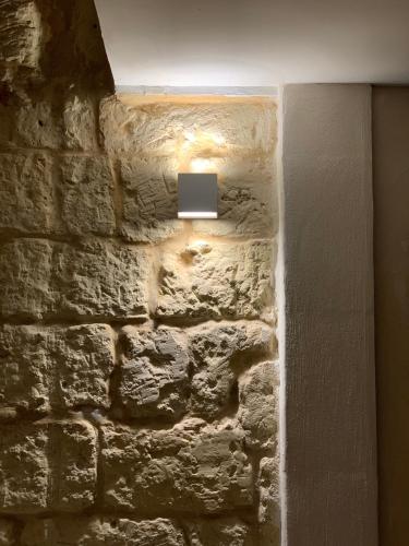 a light on the side of a brick wall at Masseria dei Monaci in Otranto